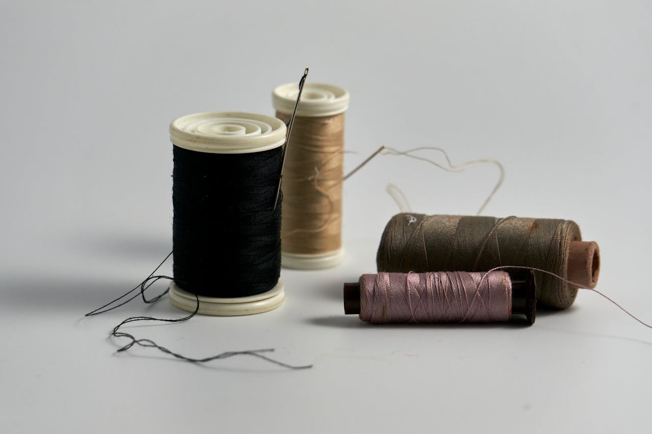 Close-up of various sewing threads and needles, ideal for crafting and tailoring scenes.